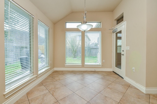 unfurnished dining area with vaulted ceiling and light tile patterned floors