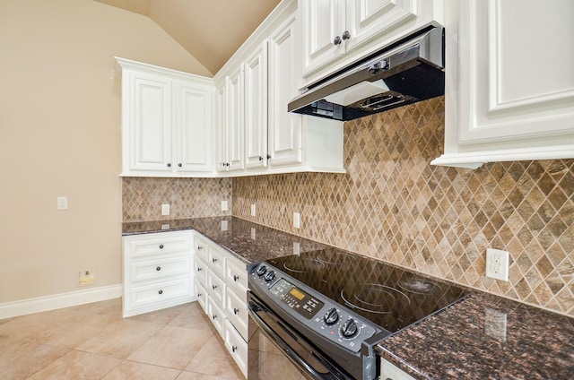 kitchen with lofted ceiling, light tile patterned floors, dark stone countertops, electric range, and white cabinets