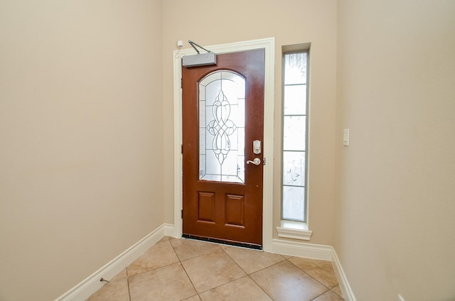 foyer featuring light tile patterned flooring and baseboards