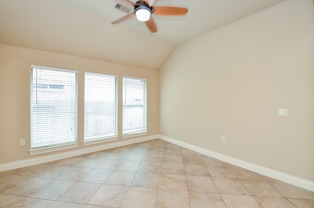 spare room with light tile patterned floors, vaulted ceiling, and ceiling fan