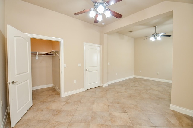 unfurnished bedroom with ceiling fan, a walk in closet, and a closet