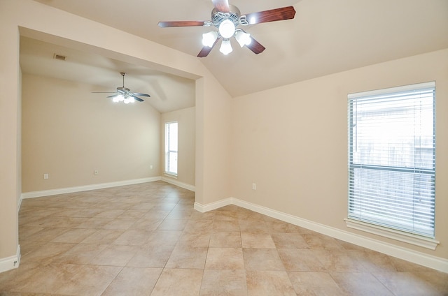 spare room with lofted ceiling, light tile patterned floors, and ceiling fan