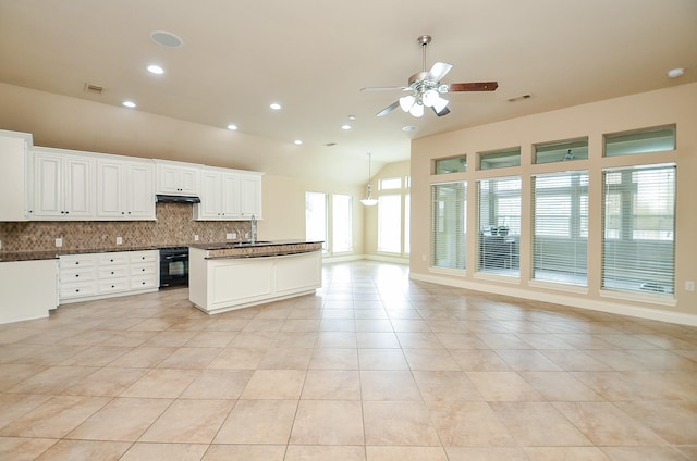 kitchen featuring tasteful backsplash, oven, white cabinets, light tile patterned floors, and ceiling fan