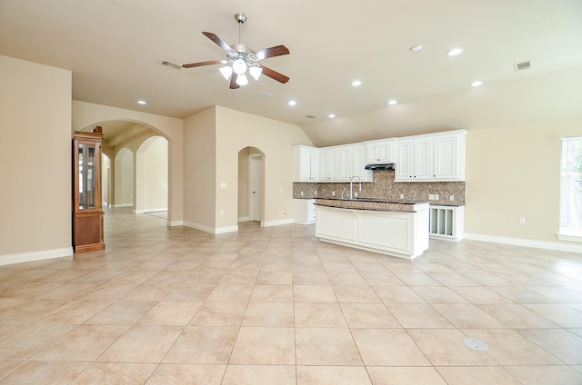 kitchen with light tile patterned flooring, sink, decorative backsplash, and white cabinets