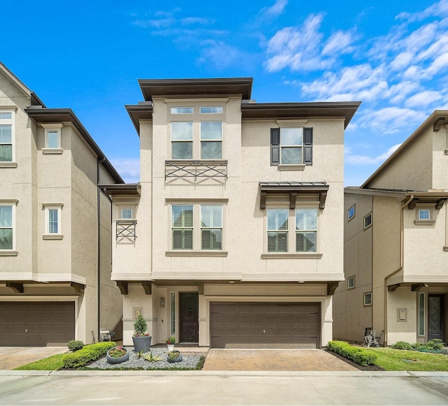 multi unit property featuring decorative driveway, an attached garage, and stucco siding