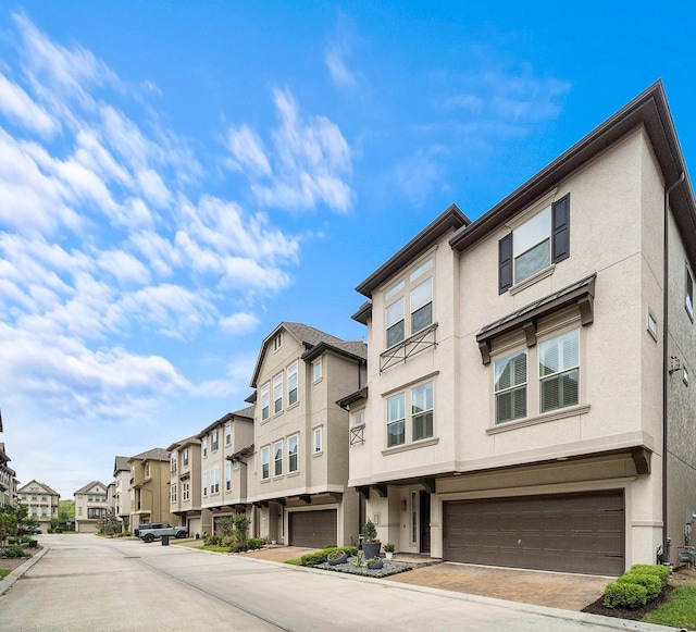 view of building exterior with a garage and a residential view