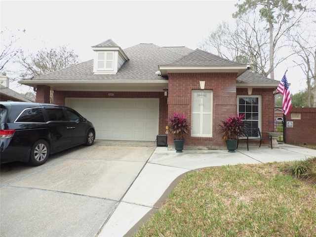 view of front of home with concrete driveway, brick siding, an attached garage, and a shingled roof