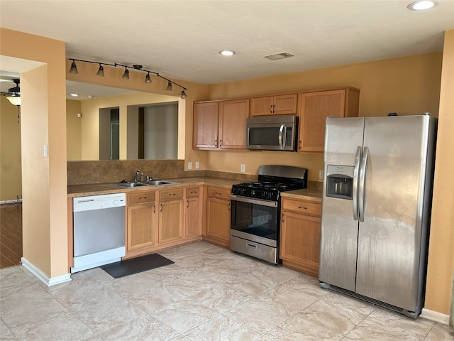 kitchen featuring ceiling fan, stainless steel appliances, and sink