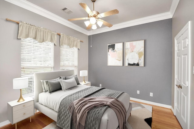 bedroom featuring crown molding, ceiling fan, and light hardwood / wood-style flooring