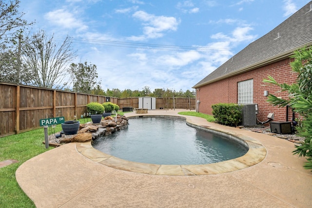 view of pool featuring an outbuilding, a fenced backyard, central AC, a storage shed, and a patio area