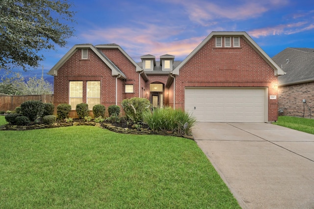 view of front of house featuring a front yard, fence, an attached garage, concrete driveway, and brick siding