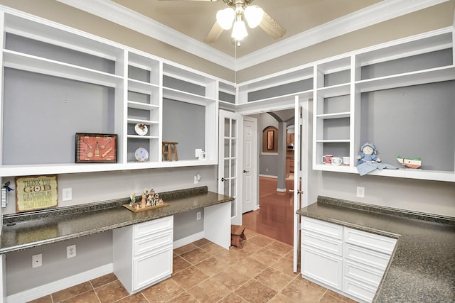 kitchen with light tile patterned flooring, white cabinetry, crown molding, built in desk, and ceiling fan