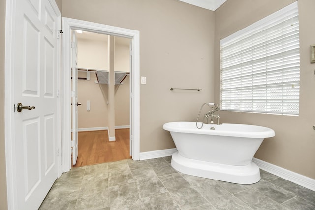 bathroom featuring baseboards and a freestanding bath