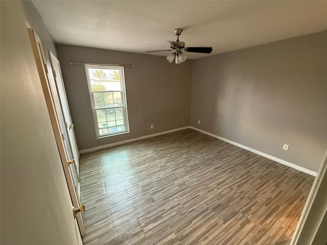 empty room featuring hardwood / wood-style flooring and ceiling fan