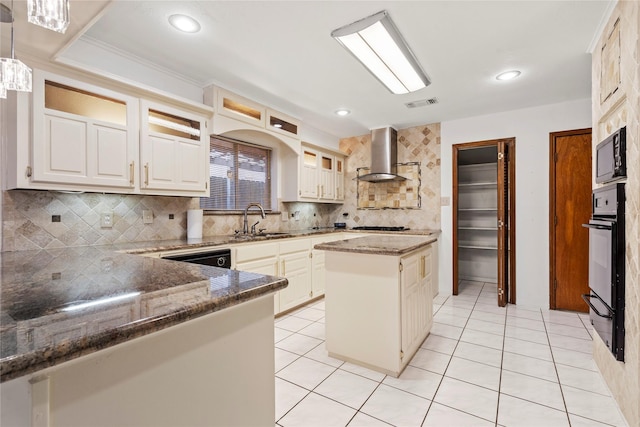 kitchen featuring light tile patterned flooring, sink, decorative light fixtures, a center island, and wall chimney range hood