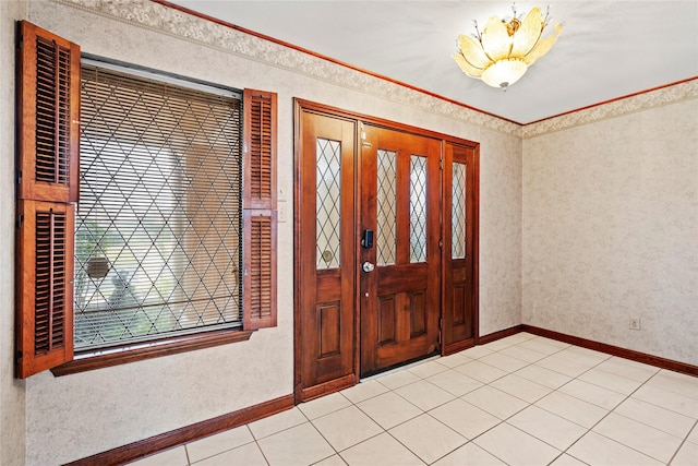 foyer entrance with light tile patterned floors and crown molding