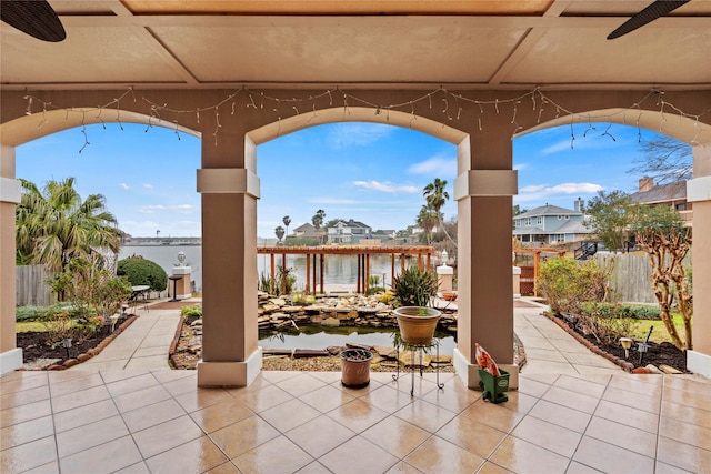 view of patio / terrace featuring a water view and ceiling fan