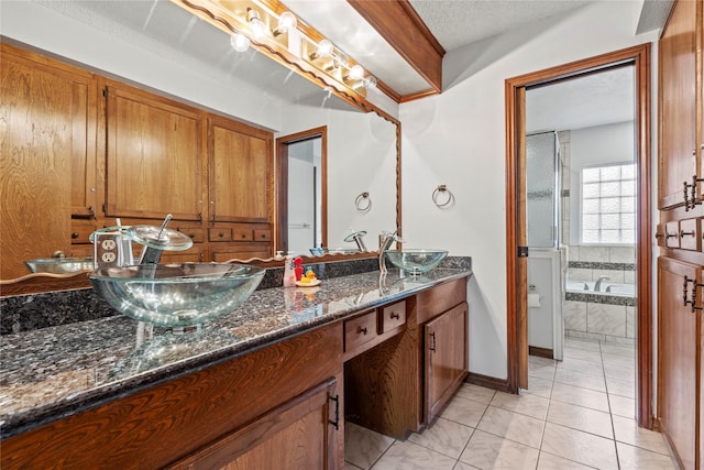 bathroom with vanity, tiled tub, tile patterned flooring, and a textured ceiling