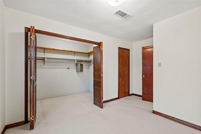 unfurnished bedroom with a closet and light carpet