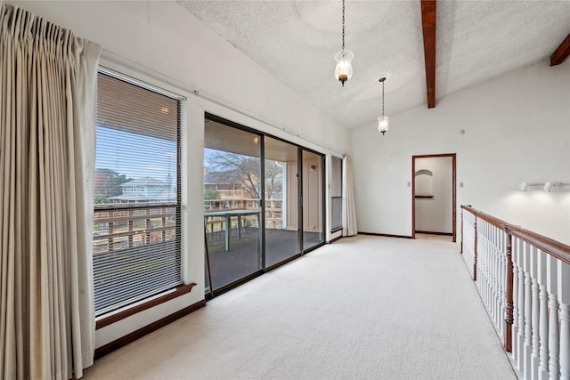 spare room with light carpet, lofted ceiling with beams, and a textured ceiling