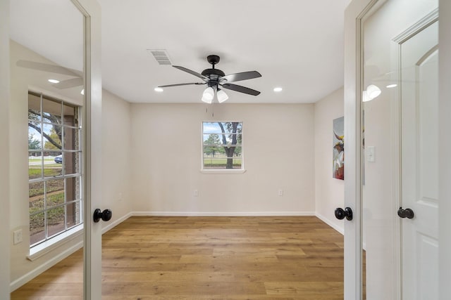 spare room featuring french doors, ceiling fan, and light hardwood / wood-style floors