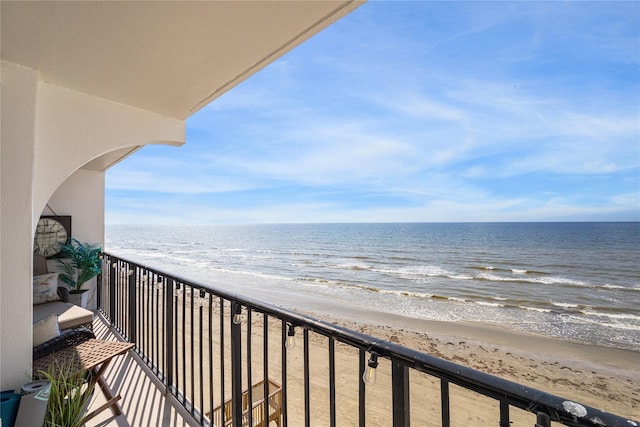 balcony featuring a water view and a view of the beach