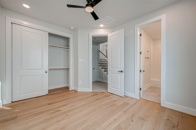 unfurnished bedroom featuring ensuite bathroom, a closet, ceiling fan, and light wood-type flooring