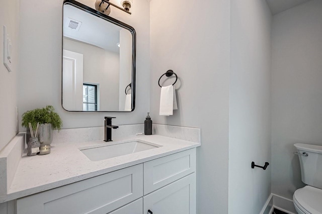 bathroom featuring visible vents, vanity, and toilet