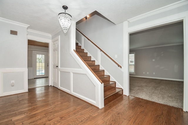 interior space with a notable chandelier, stairway, wood finished floors, and crown molding