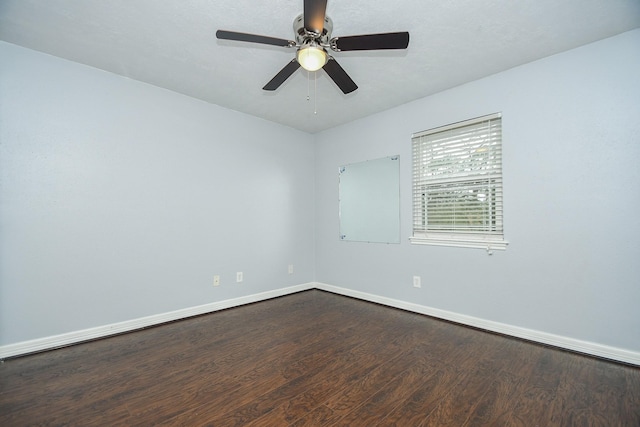 empty room featuring ceiling fan, baseboards, and wood finished floors