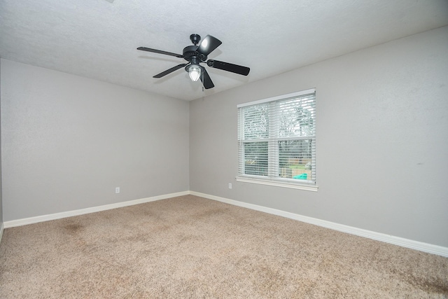 empty room featuring carpet floors, ceiling fan, baseboards, and a textured ceiling