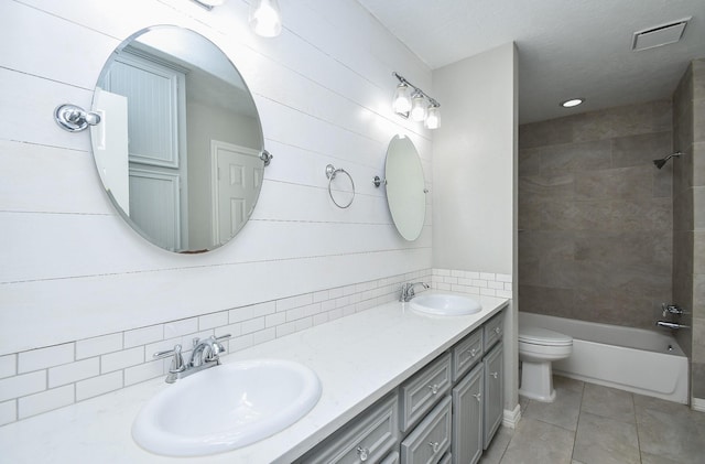 full bath featuring toilet, double vanity, a sink, and visible vents