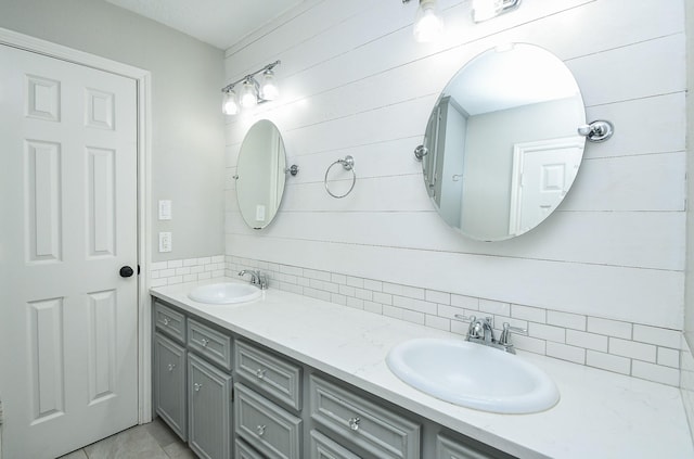 bathroom featuring double vanity, tasteful backsplash, and a sink