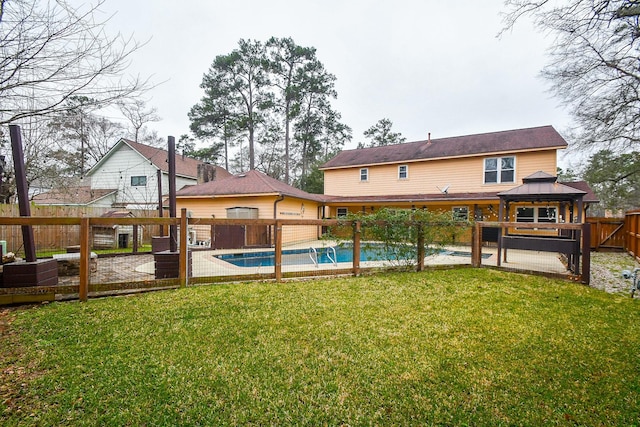 rear view of house with a fenced backyard, a lawn, a fenced in pool, and a gazebo