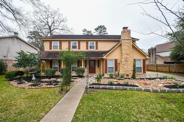 view of front of home with a front lawn, a chimney, fence, and brick siding