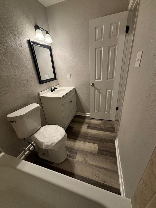 bathroom with hardwood / wood-style flooring, vanity, and toilet