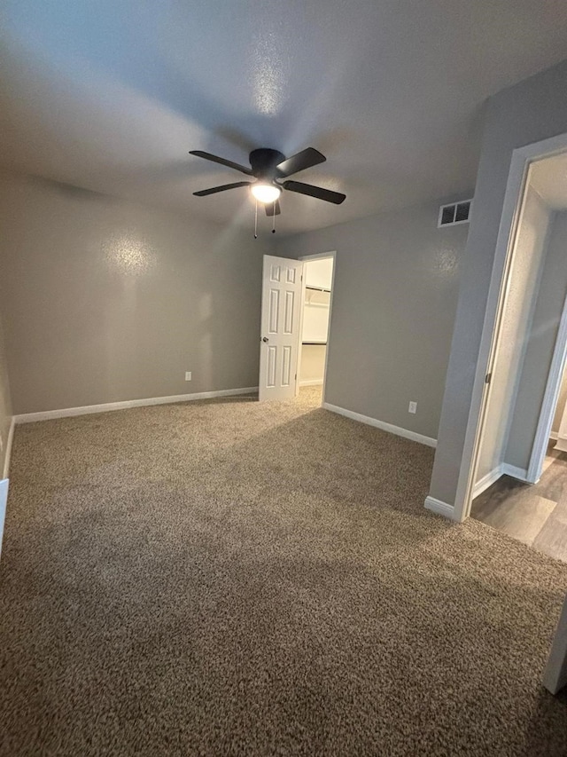 carpeted spare room featuring ceiling fan