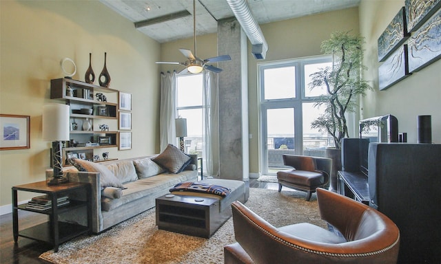 living room featuring a high ceiling, hardwood / wood-style flooring, and ceiling fan