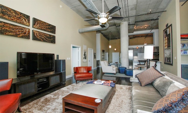 living room with a high ceiling, rail lighting, dark hardwood / wood-style flooring, and ceiling fan