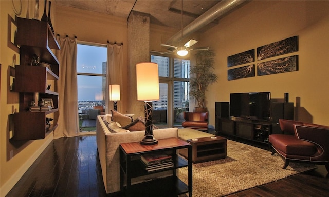 living room featuring hardwood / wood-style flooring and a towering ceiling