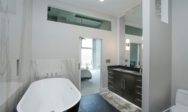 bathroom featuring vanity, toilet, and a washtub