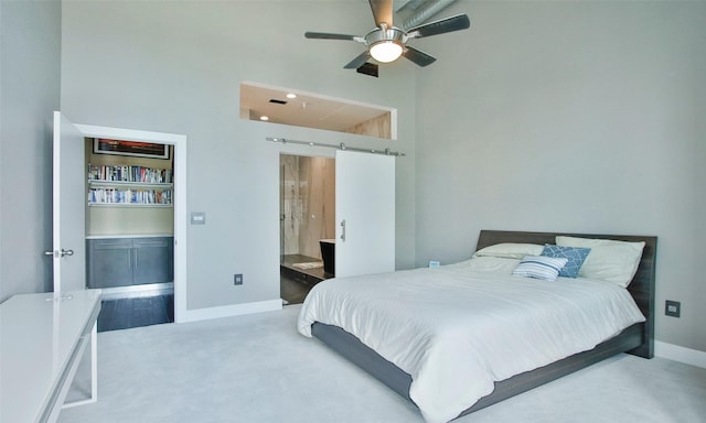 bedroom with a barn door, carpet floors, and ceiling fan