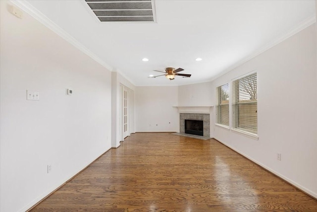 unfurnished living room featuring hardwood / wood-style flooring, ceiling fan, ornamental molding, and a tile fireplace