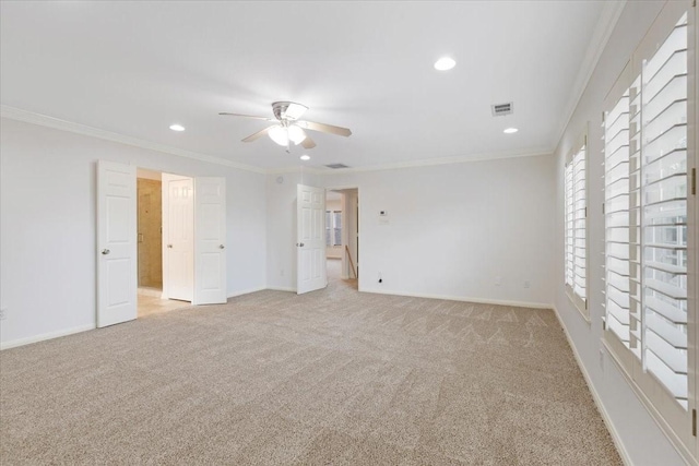 empty room with light carpet, crown molding, and ceiling fan