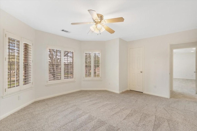 carpeted spare room featuring ceiling fan