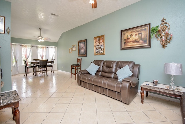 tiled living room with a textured ceiling, vaulted ceiling, and ceiling fan