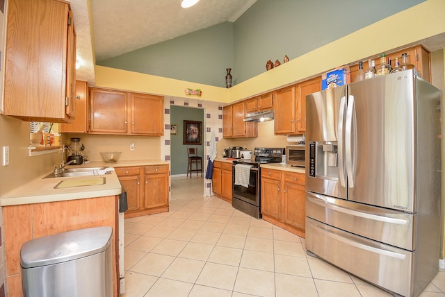 kitchen featuring appliances with stainless steel finishes, sink, light tile patterned floors, and high vaulted ceiling