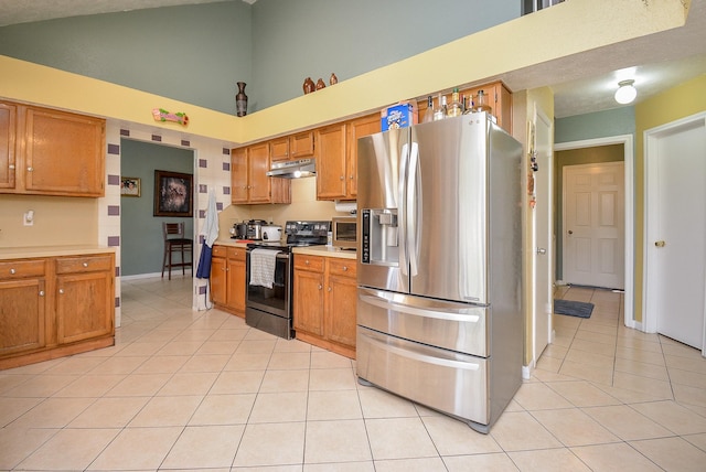 kitchen featuring high vaulted ceiling, light tile patterned flooring, and appliances with stainless steel finishes