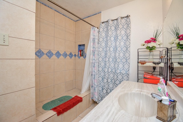 bathroom featuring a shower with curtain, sink, and a textured ceiling