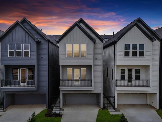 view of front of property featuring board and batten siding, concrete driveway, an attached garage, and stairs